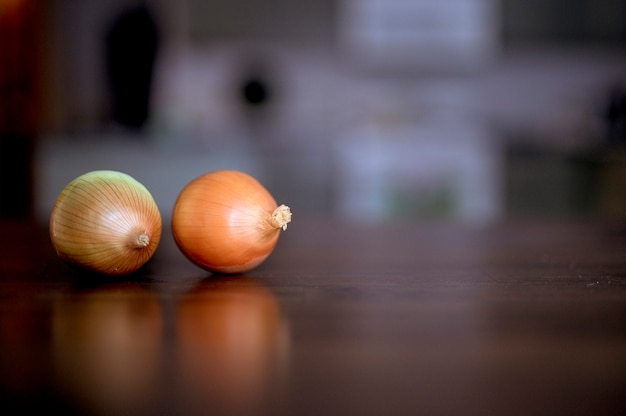 Een selectieve scherpstelling van twee uien op een houten oppervlak