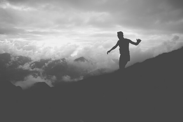 Een silhouet van een atleet rennen de hellingen van een berg