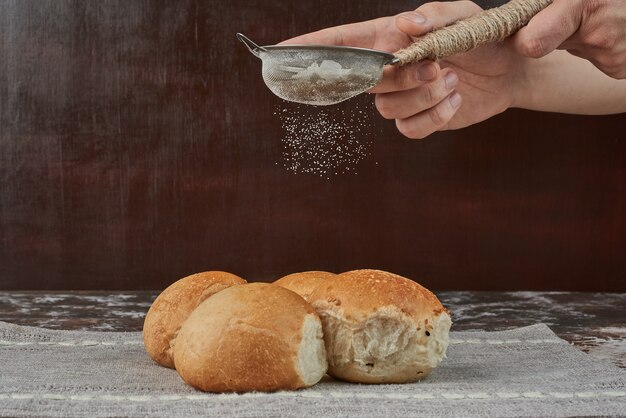 Een snufje poeder aan het brood toevoegen