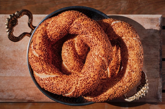 Gratis foto een stapel versgebakken turkse bagel simit in een koperen dienblad ontbijtsnacks in turkije bovenaanzicht van vers gebakken goederen