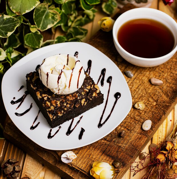 Een stukje chocolade brownie met walnoot en vanille ijs