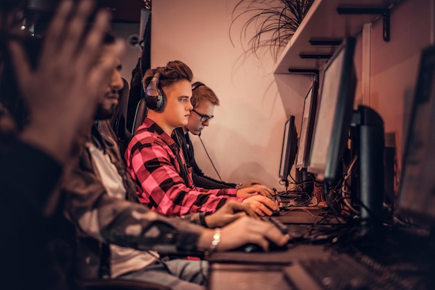 Een team tienergamers speelt in een multiplayer-videogame op pc in een gamingclub.