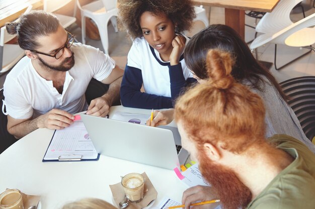 Een team van jonge collega's die bijeenkomen in een café.
