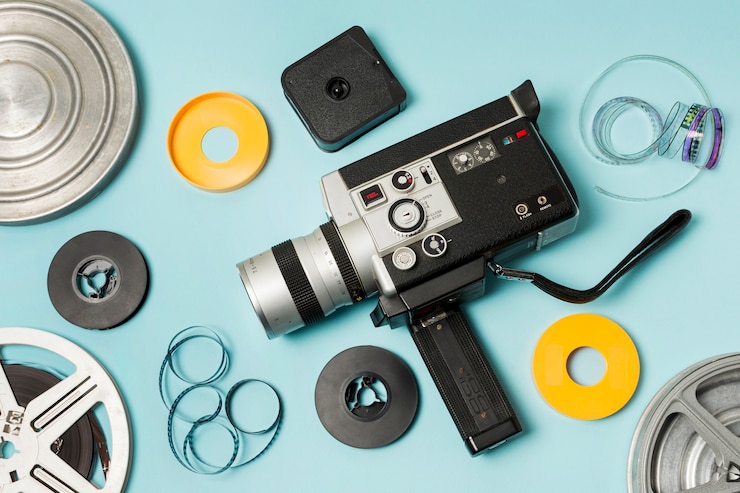 Gratis Foto een verhoogd beeld van een filmrol; filmstroken en camcorder op blauwe achtergrond