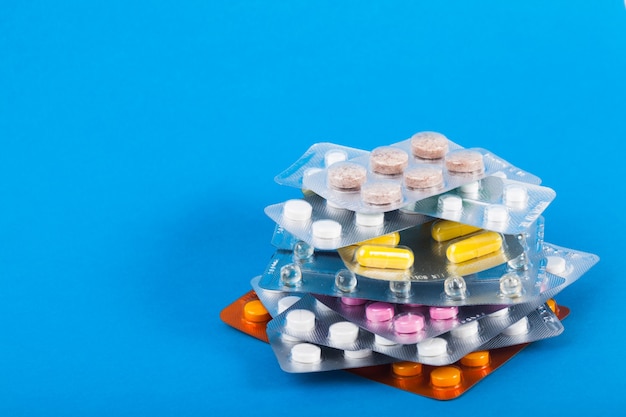 Een verscheidenheid aan tabletten in verpakkingen op blauwe achtergrond