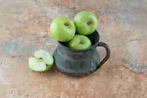 Gratis foto een verse appels met een oude beker op marmeren tafel.