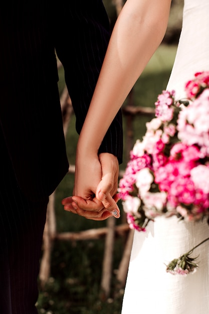 Gratis foto een voor dichte omhooggaande meningspaar die van man en vrouw elkaars handen houden tijdens huwelijk