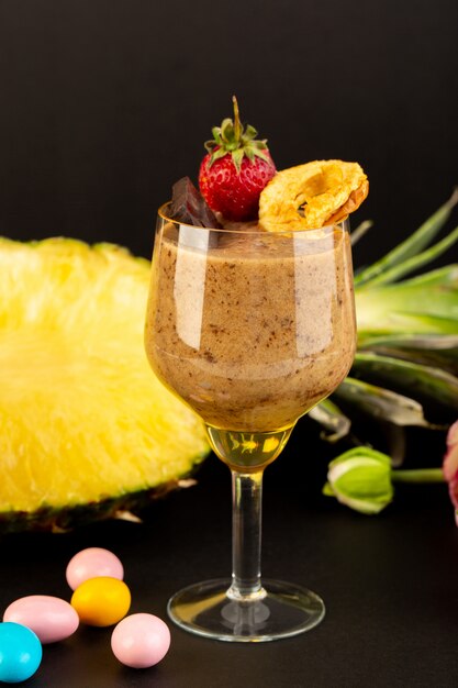 Een vooraanzicht bruin chocodessert smakelijk heerlijk zoet met gemalen koffiechocobar en aardbei met gesneden exotische ananas op de donkere achtergrond zoet verfrissend dessert