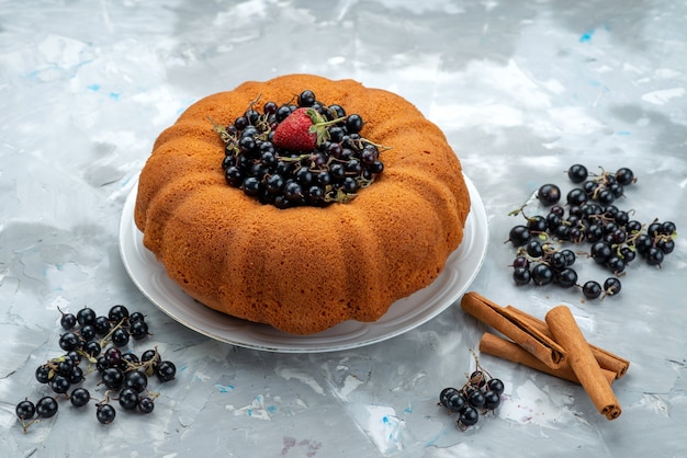 Gratis foto een vooraanzicht fruitcake heerlijk en rond gevormd met vers blauw, bessen op helder, cake biscuit zoete suiker