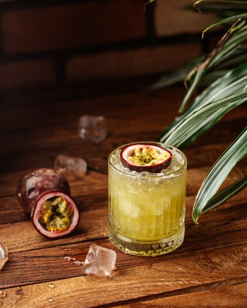 Een vooraanzicht fruitcocktail met ijsblokjes op de houten bureau fruitcocktail drinkt sap