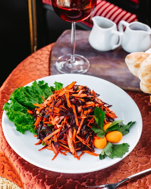 Een vooraanzicht gebakken groenten gekleurd vitamine rijk samen met groene salade in witte plaat op tafel