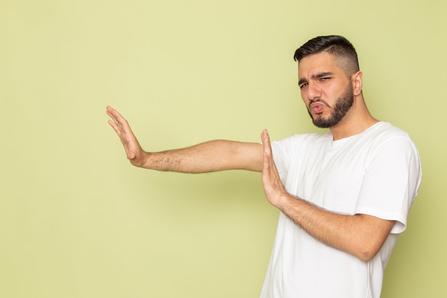 Een vooraanzicht jong mannetje in wit t-shirt dat sociale regels op afstand houdt