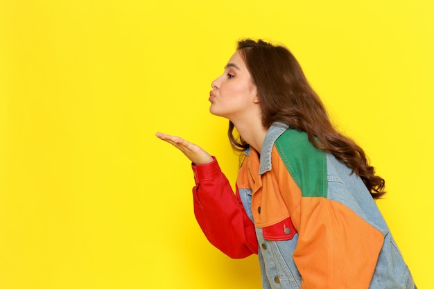 Een vooraanzicht jong mooi meisje in rode overhemdlaag en jeans die luchtkussen verzenden