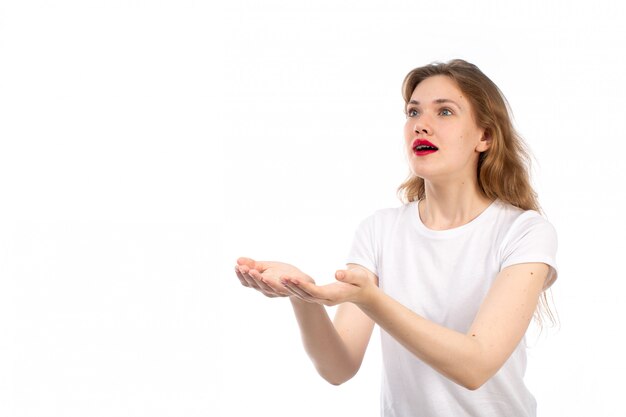 Een vooraanzicht jonge dame in het witte t-shirt stellen verrast opgewekt op het wit