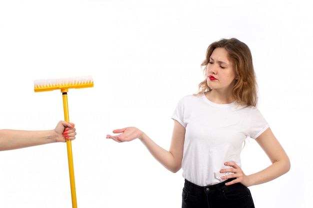 Een vooraanzicht jonge dame in wit overhemd en zwarte broek krijgen gele mop ontevreden op het wit