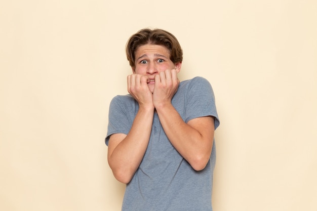 Gratis foto een vooraanzicht jonge man in grijs t-shirt poseren met bange uitdrukking