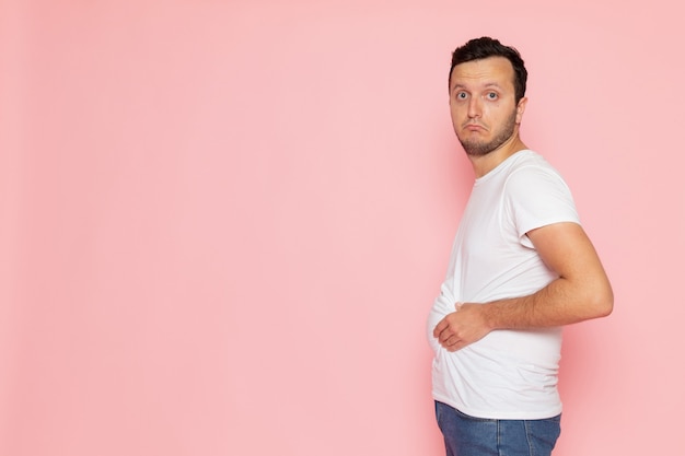 Een vooraanzicht jonge man in wit t-shirt alleen poseren