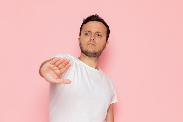 Een vooraanzicht jonge man in wit t-shirt met stopbord