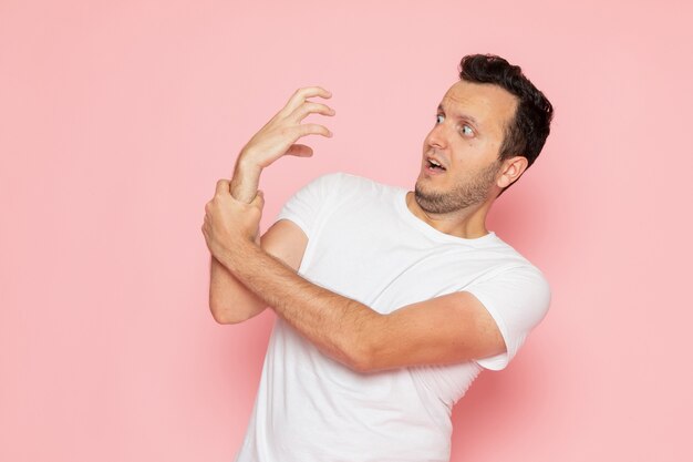 Een vooraanzicht jonge man in wit t-shirt poseren met grappigste manier