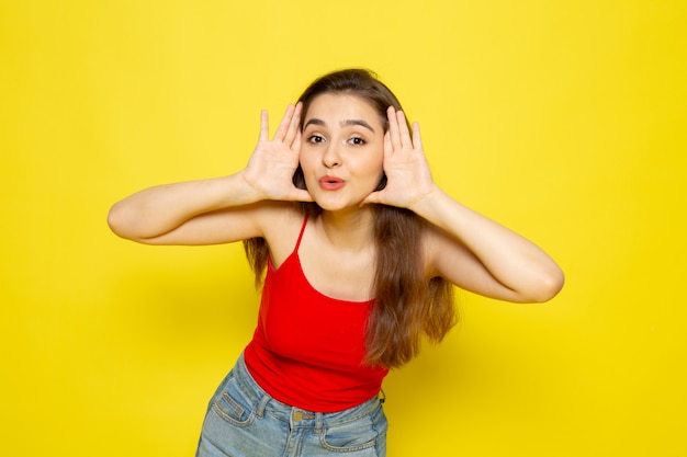 Een vooraanzicht jonge mooie dame in rood overhemd en jeans face-posing