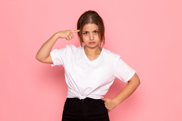 Een vooraanzicht jonge mooie vrouw in wit overhemd poseren met boze uitdrukking