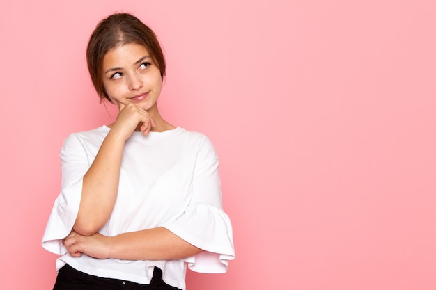 Een vooraanzicht jonge mooie vrouw in wit overhemd poseren met dromen expressie