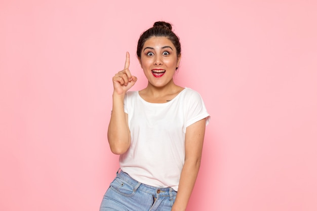 Een vooraanzicht jonge vrouw in wit t-shirt en spijkerbroek poseren met emotionele expressie