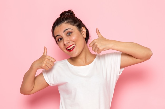 Een vooraanzicht jonge vrouw in wit t-shirt en spijkerbroek poseren met emotionele expressie