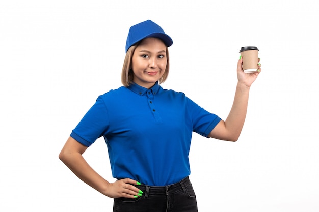 Een vooraanzicht jonge vrouwelijke koerier in blauw uniform koffiekopje te houden