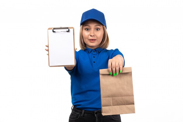 Een vooraanzicht jonge vrouwelijke koerier in blauw uniform met voedselbezorgingspakket en blocnote voor handtekeningen