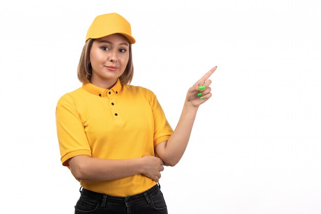 Een vooraanzicht jonge vrouwelijke koerier in het gele uniform poseren met een glimlach