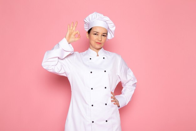 Een vooraanzicht jonge vrouwelijke kok in wit kokkostuum wit GLB het glimlachen stellen