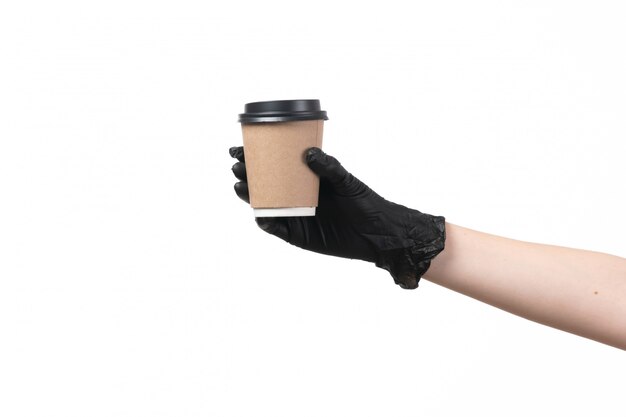 Een vooraanzicht koffiekopje greep door vrouw in zwarte handschoenen