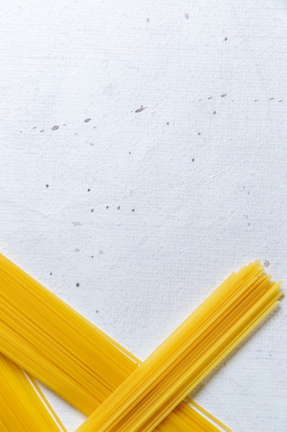 Een vooraanzicht rauwe Italiaanse pasta lang gevormd op de witte tafel pasta Italiaanse maaltijd