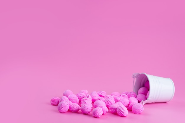 Een vooraanzicht roze, snoepjes binnen en buiten klein wit, mandje op roze, snoep kleurensnoepjes