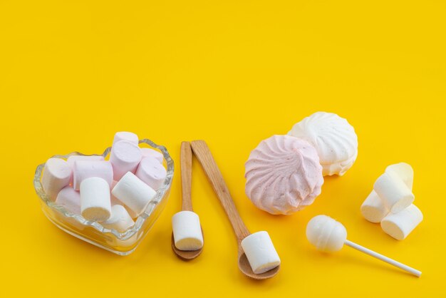 Een vooraanzicht schuimgebak en marshmallows zoet en heerlijk op gele, suikerzoete snoepkleur