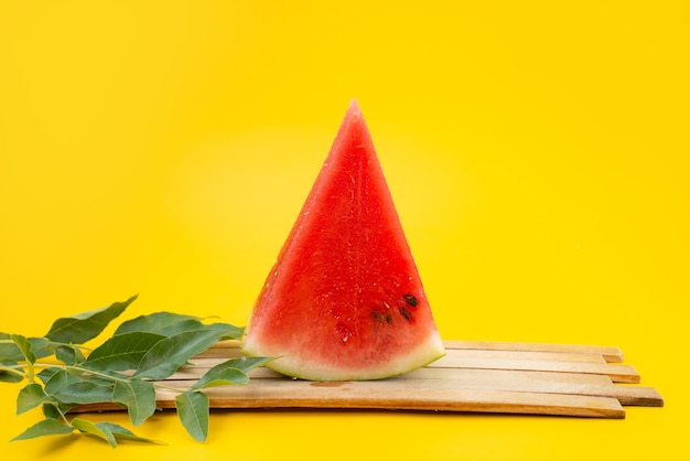 Een vooraanzicht vers gesneden watermeloen samen met bladeren op de bruine houten zomer van het kleurenfruit