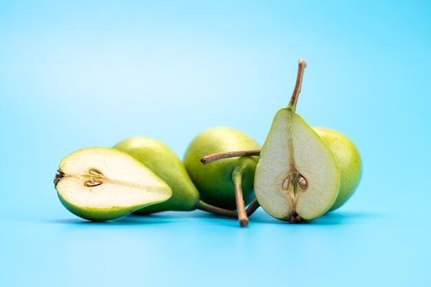 Een vooraanzicht verse groene peren zoet en zacht op blauw, fruitkleur rijp