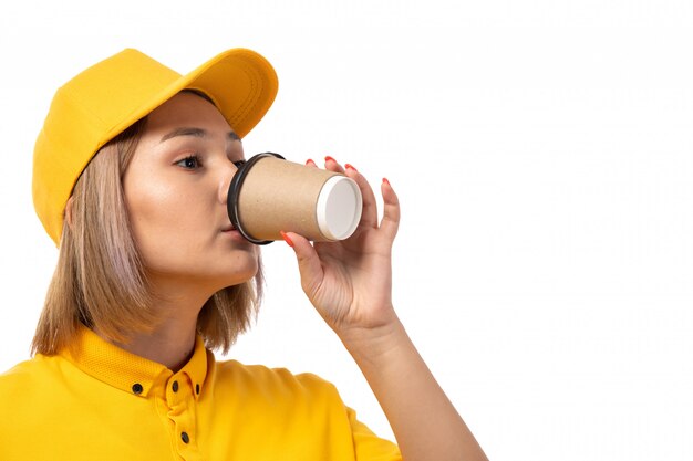 Een vooraanzicht vrouwelijke koerier het drinken koffie bij het witte dienst leveren als achtergrond