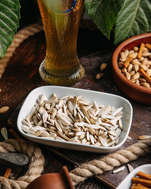 Een vooraanzicht witte zaden die met noten op het houten de snackzaad van de lijstnoot worden gezouten