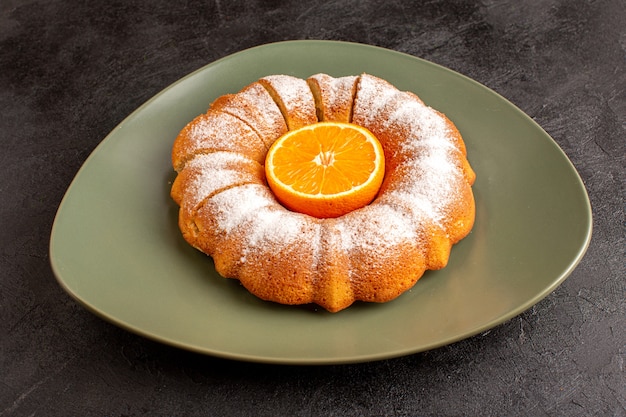 Een vooraanzicht zoete ronde cake met suiker poeder toverstaf oranje in het midden gesneden zoet heerlijk binnen bord en op de grijze achtergrond biscuit suiker koekje