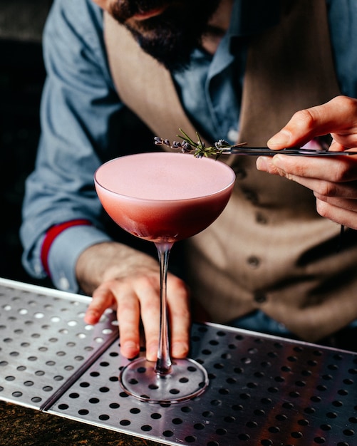 Een vooraanzichtbarman die cocktail op de cocktail van het het sapdrankje van het barbureau voorbereidt