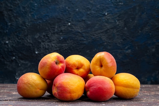 Een vooraanzichtperziken zacht en sappig op de houten pulp van de de zomerfoto van het bureaufruit