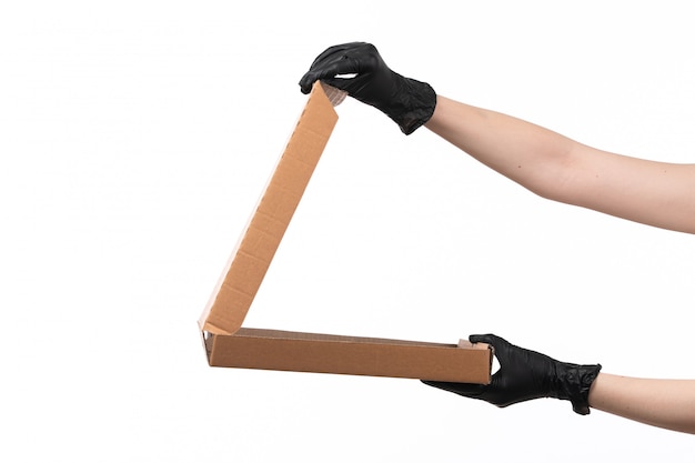 Een vooraanzichtvrouw dient zwarte handschoenen in houdend een lege pizzadoos op wit