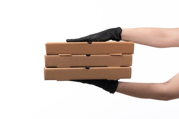 Een vooraanzichtvrouw dient zwarte handschoenen in houdend pizzadozen op wit