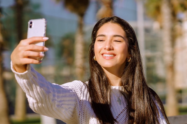 Een vrolijke brunette met een brede glimlach die een selfie doet