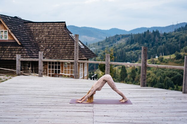 Een vrouw beoefent yoga in de ochtend op een terras in de frisse lucht.