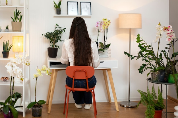 Gratis foto een vrouw die haar huis met orchideeën versiert