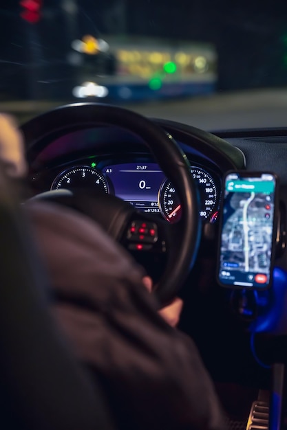 Een vrouw die's nachts in de stad met haar moderne auto rijdt.