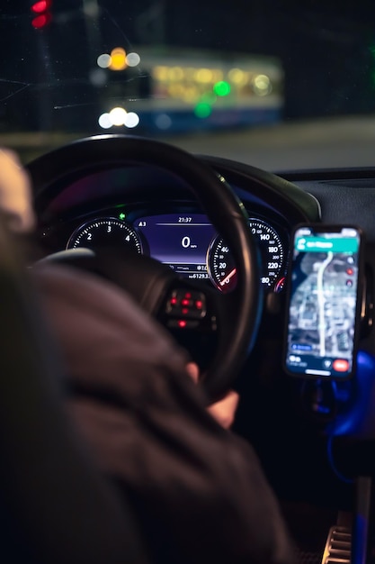 Een vrouw die's nachts in de stad met haar moderne auto rijdt.